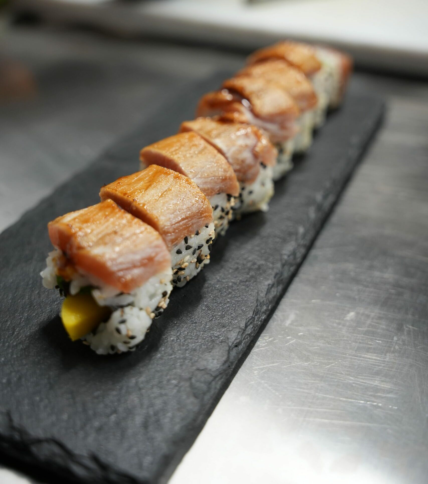 Sushi gourmet au saumon grillé chez Omley Sushinem à Castelnau-le-Lez, makis raffinés sur ardoise noire,