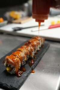 Rouleau de sushi gastronomique nappé de sauce chez Omley Sushinem à Castelnau-le-Lez,