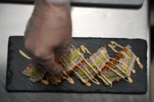 Chef d’Omley Sushinem dressant des makis gourmets sur ardoise noire à Castelnau-le-Lez,