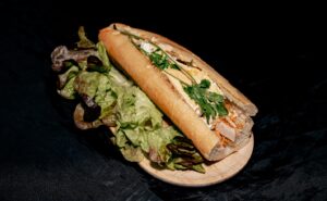 banh mi vietnamien garni chez Omley Sushinem à Castelnau-le-Lez sur planche en bois, ingrédients frais colorés,