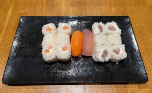 Assortiment de sushis frais chez Omley Sushinem à Castelnau-le-Lez sur plateau en bois noir,